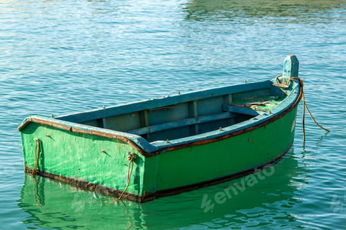 Preview: Green boat in sunlit water reflecting sunlight and objects around