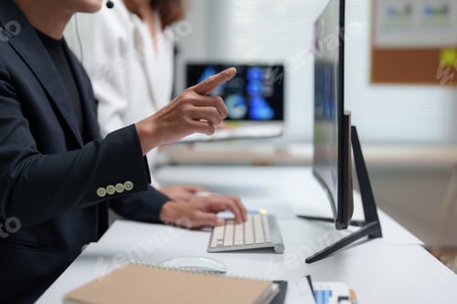 Preview: Business people working together using computer and analyzing charts in modern office