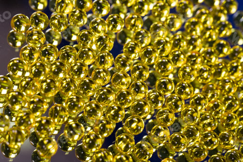 Preview: yellow medical capsules on a mirror surface