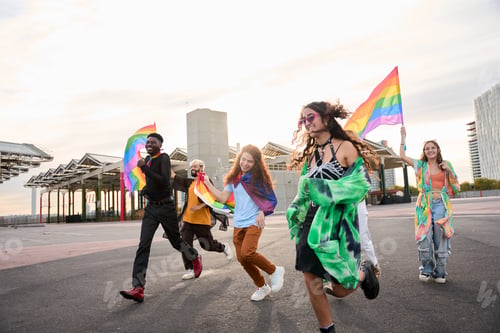 Preview: A happy group dances down the street holding rainbow flags
