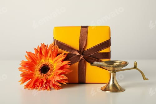 Preview: Copper lamp, gift box and flower on light background