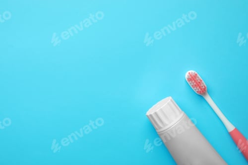 Preview: Blank tube of toothpaste and brush on color background, top view with space for text