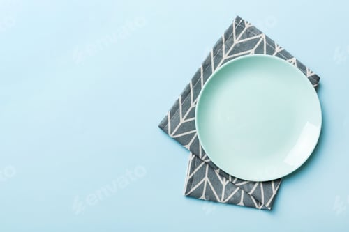 Preview: Top view on colored background empty round blue plate on tablecloth for food