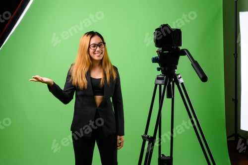 Preview: Portrait of young Asian businesswoman against green background