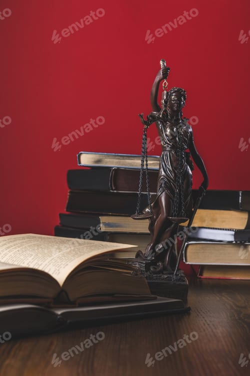 Preview: opened juridical books with lady justice statue on wooden table, law concept