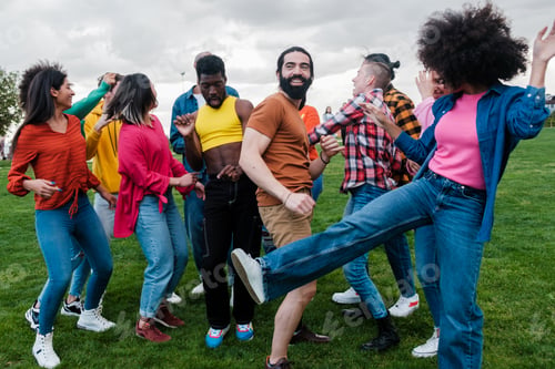 Preview: Multicultural group of young people having a fun time dancing outdoors