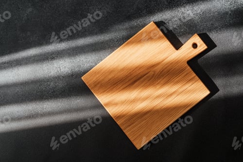 Preview: Wooden cutting board showcases natural grain under sunlight on textured surface