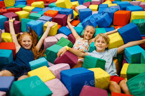 Preview: Happy children lying in soft cubes, playroom