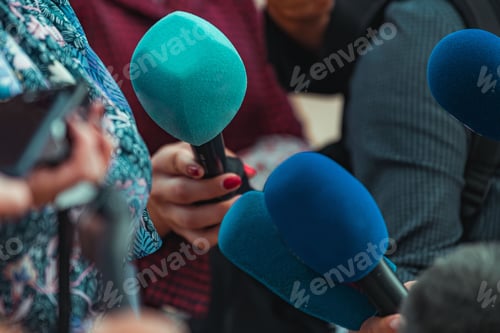 Preview: News reporters interviewing a group unrecognizable people outdoors
