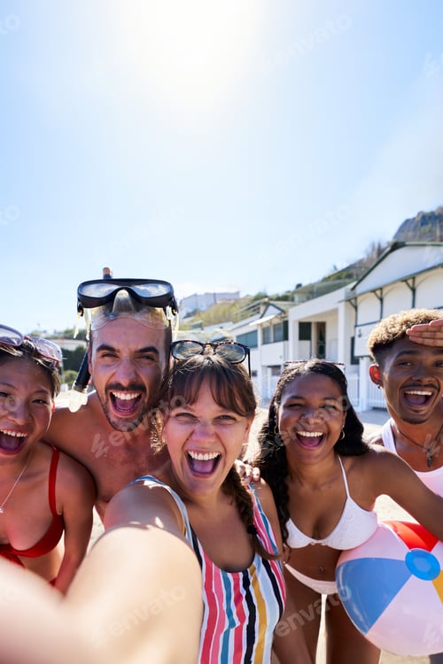 Preview: Cheerful Selfie of multiracial group of friends on the beach having fun outdoors looking at camera.