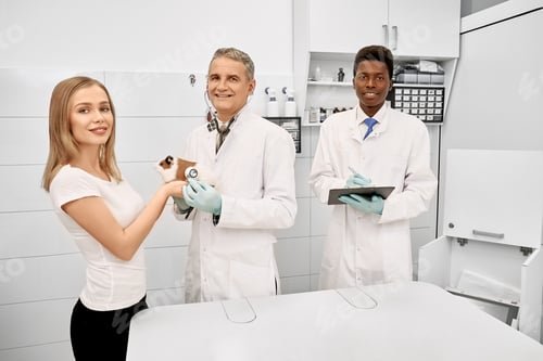 Preview: Vet, assistant and owner of hamster posing in clinic