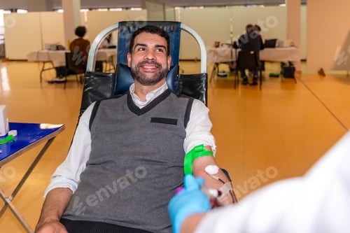 Preview: Altruist smiling man donating blood in a pavilion