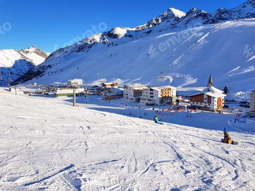 Preview: Idyllic ski resort in alps. Buildings and hotels under snow capped mountain peaks in Kuhtai, Austria