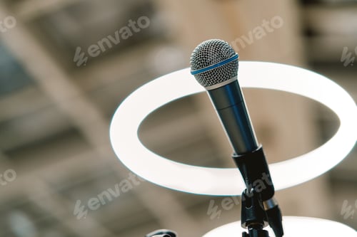 Preview: Microphone stands on a stand on the stage against the background of round lamps