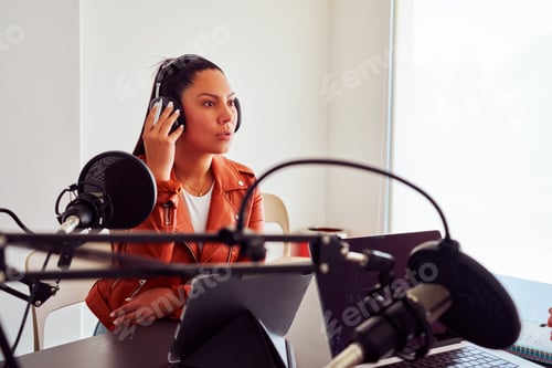 Preview: Radio host wearing headphones speaking into microphone in studio