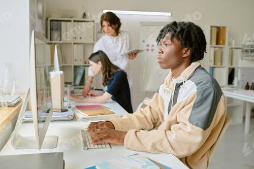 Preview: Student Typing on Computer in Modern Office Setting