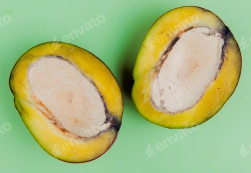 Preview: close-up view of half cut mango on green background