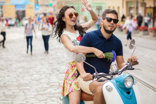 Preview: young beautiful hipster couple riding on motorbike city street