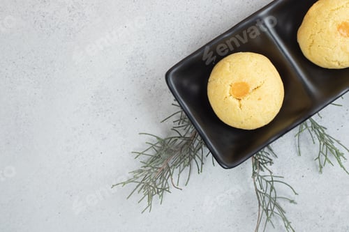 Preview: A dark plates with two round sweet cookies on white background