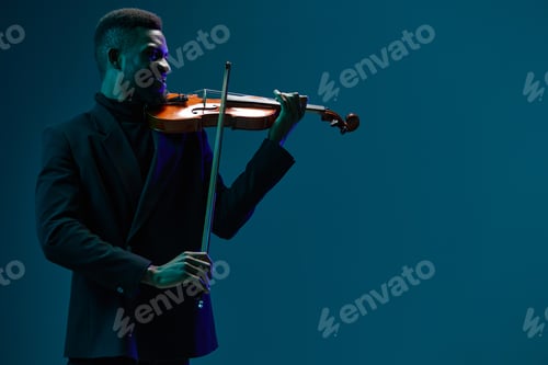 Preview: Elegant musician in black suit performing on violin against vibrant blue backdrop on stage