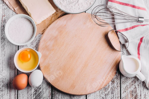 Preview: Ingredients for baking Easter cake - eggs, flour, milk, butter, sugar on wooden board.