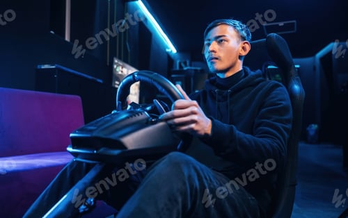 Preview: In the seat. Young guy is playing racing game by using driving simulator
