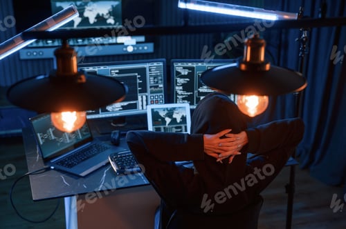 Preview: Young professional female hacker is indoors by computer with lot of information on displays