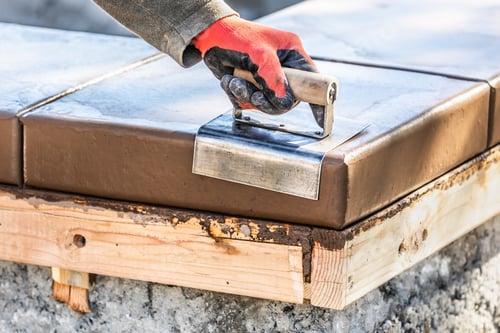 Preview: Construction Worker Using Stainless Steel Edger On Wet Cement Forming Coping Around New Pool