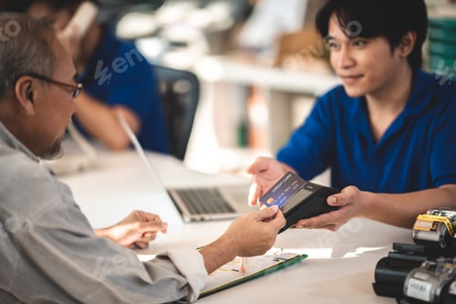 Preview: Efficient Business Transactions: Asian Man and Female Salesperson Manage Payment and Bill