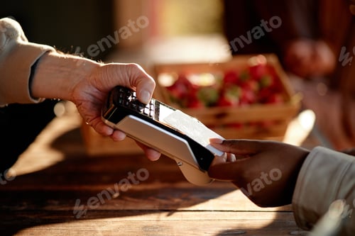 Preview: Caucasian Man Accepting Contactless Payment from Black Woman Outdoors