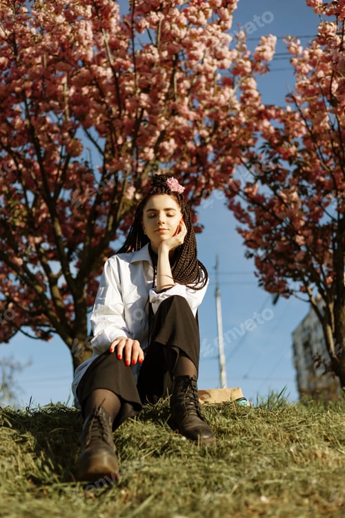 Preview: beautiful young teen girl in spring blooming cherry blossoms garden