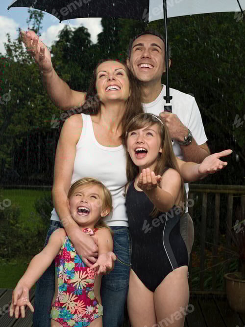 Preview: A family under an umbrella in the rain