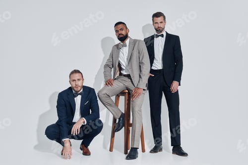 Preview: Three handsome young men in suits and bowties looking at camera