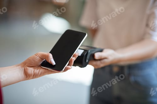 Preview: Wireless Payment. Close up female hand using smartphone, paying contactless at cafe