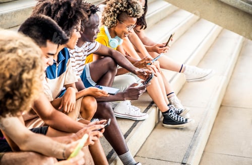 Preview: Teenage students using digital smart mobile phones on college campus