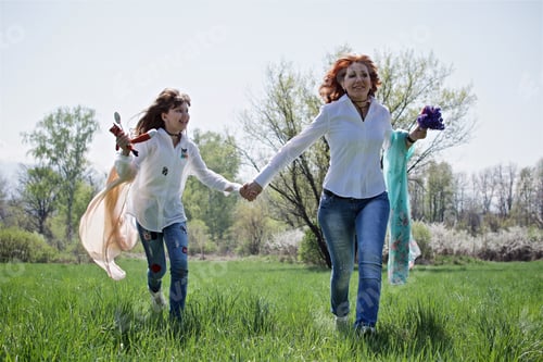 Preview: Young woman and a little daughter having fun in the spring botanical garden