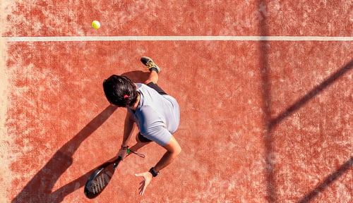 Preview: Top view of a paddle tennis player who is hitting the ball on an outdoor court.