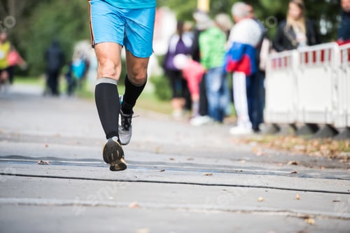 Preview: Legs of unrecognizable runner outdoors. Long distance running.