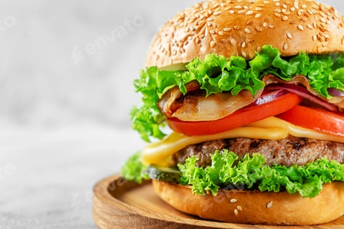 Preview: Close up of hamburger with bacon and cheese on gray background. Unhealthy eating, fast food.