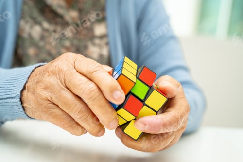 Preview: Asian elderly woman patient playing Rubik cube game to practice brain