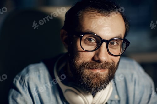 Preview: Man in headphones working with information in dark office