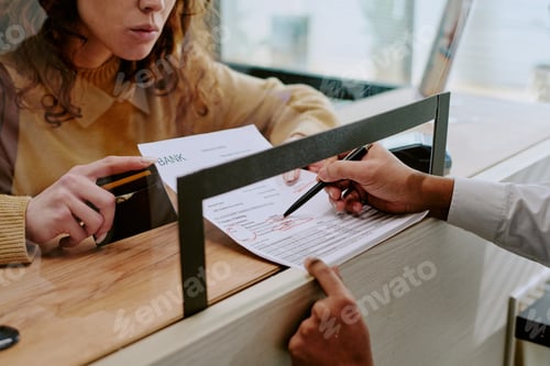 Preview: Person Filling Out Bank Documents in Office