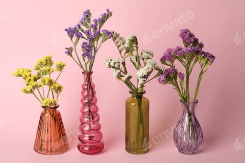 Preview: Beautiful flowers in glass vases on pink background