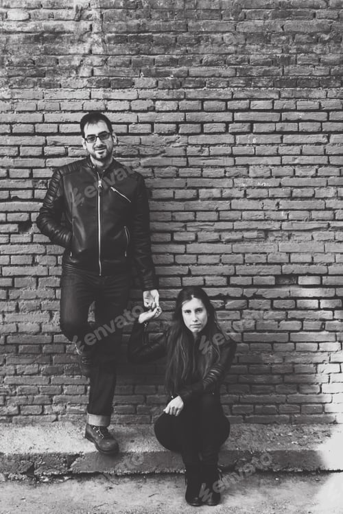 Preview: Casual portrait of a couple in love and piggyback dressed in black leather