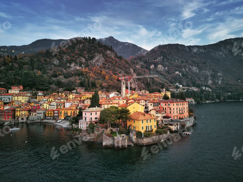 Preview: Drone view of Lake Como surrounded by a town and mountains in the evening in Italy