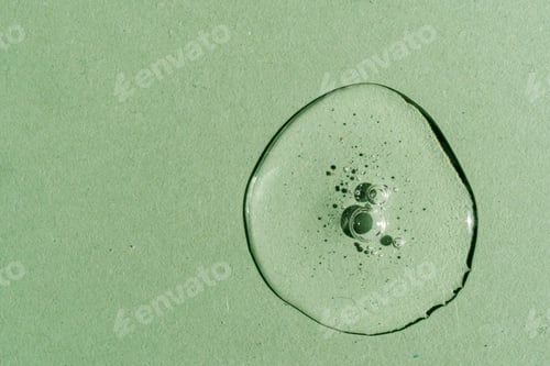 Preview: A drop of transparent cosmetic gel on a green background.
