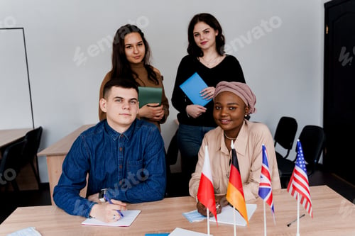 Preview: Teamwork in multilingual group with teacher and laptops; black girl included