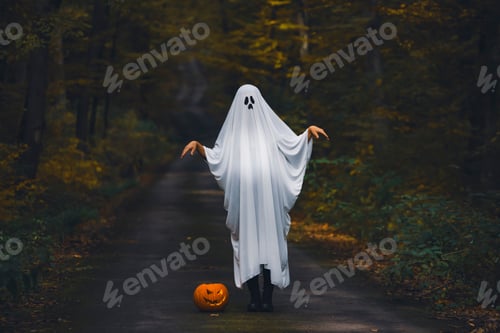 Preview: Ghostly figure with pumpkin in enchanted a forest on a moody autumn day.