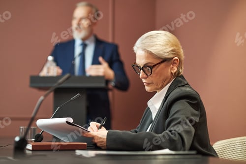 Preview: Senior Caucasian Woman Politician Taking Notes during Political Conference