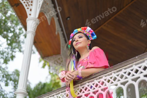 Preview: Mexican woman wearing traditional dress with multicolored embroidery celebrating independence day.